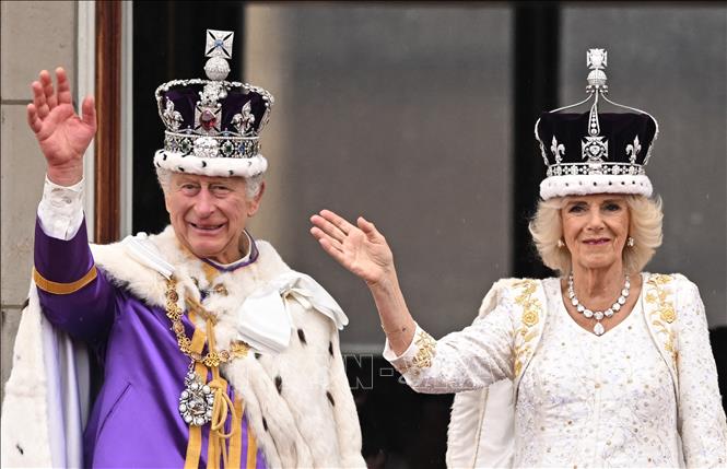 Nhà Vua Charles III, Hoàng hậu Camilla trên ban công Cung điện Buckingham vẫy chào người dân, sau khi xem màn biểu diễn của không quân Anh mừng lễ đăng quang, ngày 6/5/2023. Ảnh: AFP/TTXVN