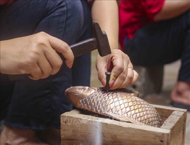 Quá trình chạm khắc các chi tiết trên bề mặt sản phẩm yêu cầu sự cần cù, tỉ mỉ. Ảnh: Tuấn Đức - TTXVN