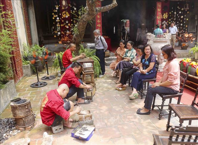 Buổi trình diễn kỹ thuật đúc đồng của làng nghề Ngũ Xã thu hút nhiều du khách. Ảnh: Tuấn Đức - TTXVN