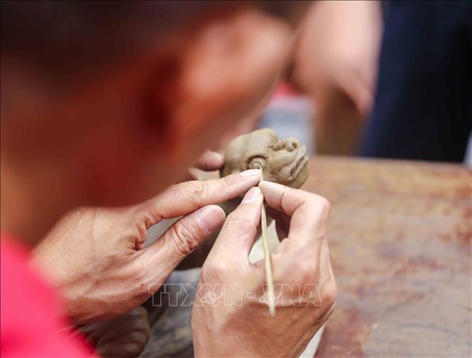 Nghệ nhân Nguyễn Thanh Tuấn (làng nghề Ngũ Xã) tỉ mỉ với công đoạn tạo mẫu. Ảnh: Tuấn Đức - TTXVN