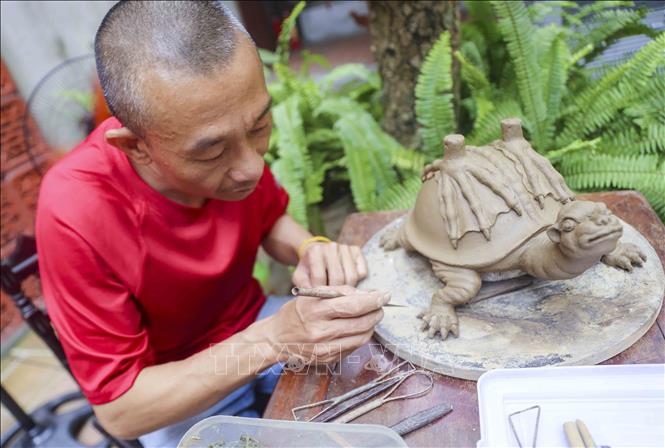 Nghệ nhân Nguyễn Thanh Tuấn (làng nghề Ngũ Xã) tỉ mỉ với công đoạn tạo mẫu. Ảnh: Tuấn Đức - TTXVN