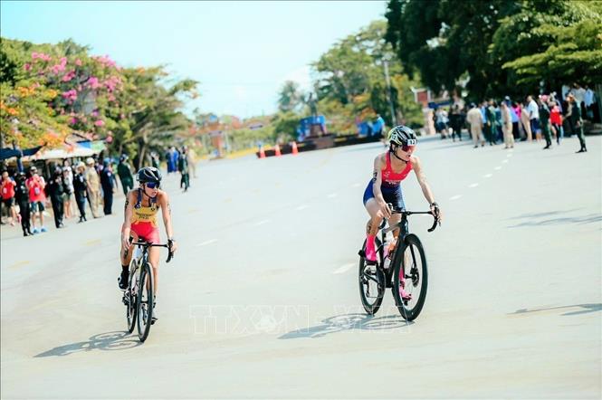 VĐV Nguyễn Thị Phương Trinh (phải) của Việt Nam tranh tài ở phần thi đua xe đạp. Ảnh: AKP/TTXVN phát 