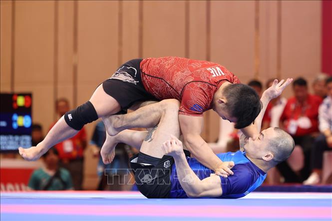 Đào Hồng Sơn (áo đỏ) và thắng Tang Yong Siang (Singapore, áo xanh) nội dung đối kháng Ne-Waza Nogi nam - hạng 56kg, giành HCV. Ảnh: Minh Quyết - TTXVN