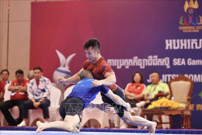 Đào Hồng Sơn (áo đỏ) và thắng Tang Yong Siang (Singapore, áo xanh) nội dung đối kháng Ne-Waza Nogi nam - hạng 56kg, giành HCV. Ảnh: Minh Quyết - TTXVN