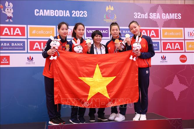 4 nữ VĐV Trương Thị Thương, Đinh Thị Hương, Nguyễn Thị Ngoan, Hoàng Thị Mỹ Tâm cùng HLV trên bục nhận HCV nội dung Kumite đồng đội nữ. Ảnh: Hoàng Linh-TTXVN