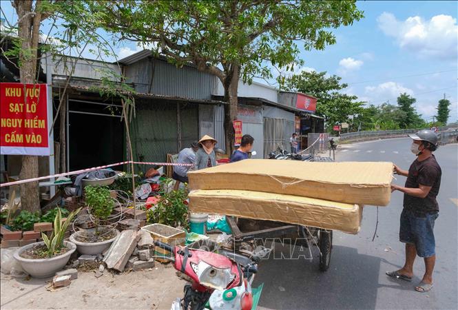 Người dân di dời tài sản, đồ đạc sau khi sạt lở xảy ra. Ảnh: Thanh Liêm - TTXVN