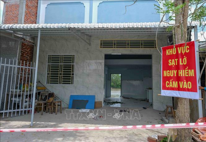 Các ngôi nhà bị sạt lở được căng dây, treo biển cảnh báo nguy hiểm. Ảnh: Thanh Liêm - TTXVN