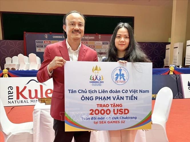 Đoàn Thị Hồng Nhung thay mặt đội tuyển Cờ ốc nhận tượng trưng tiền thưởng từ Chủ tịch Liên đoàn cờ Việt Nam sau khi giành HCV nội dung cờ tiêu chuẩn cá nhân 60 phút nữ. Ảnh: TTXVN phát