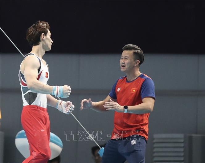 Đinh Phương Thành (trái) chia vui cùng HLV sau khi kết thúc hoàn hảo bài thi Xà kép. Ảnh: TTXVN