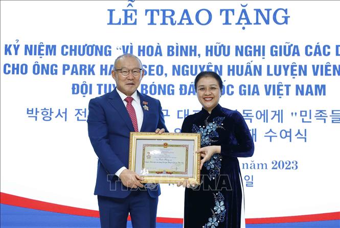 VUFO President Nguyen Phuong Nga presents the insignia to former head coach of the Vietnamese national football team Park Hang-seo. VNA Photo: An Đăng