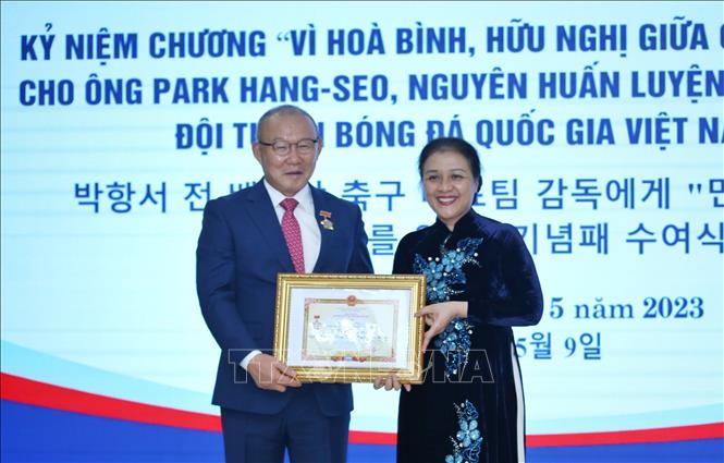 VUFO President Nguyen Phuong Nga presents the insignia to former head coach of the Vietnamese national football team Park Hang-seo. VNA Photo: An Đăng