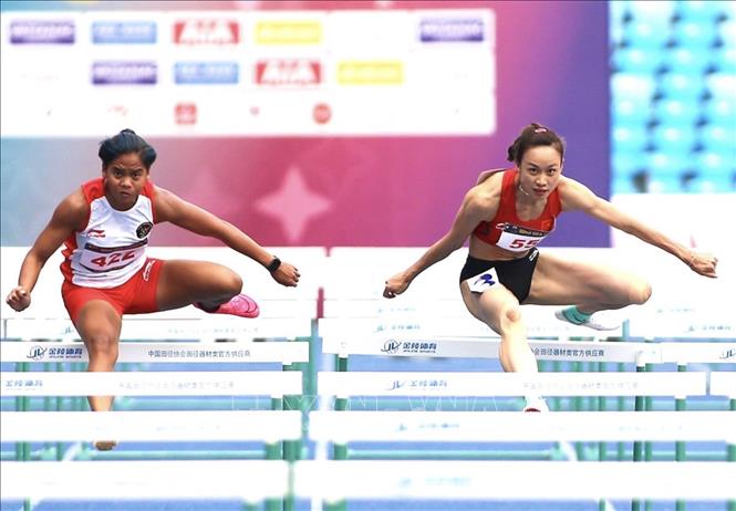 VĐV Huỳnh Thị Mỹ Tiên (phải) trên đường chạy 100m rào nữ. Ảnh: Minh Quyết - TTXVN
