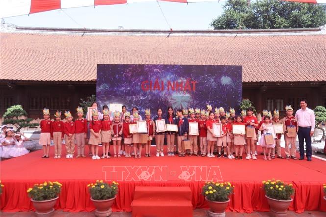 Trao giải cho các em đoạt giải Nhất cuộc thi “Sáng tác về Thầy giáo Chu Văn An”. Ảnh: Đinh Thuận - TTXVN