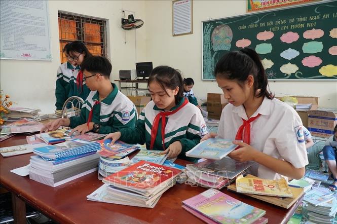 Với tinh thần “Lá lành đùm lá rách”, “Tương thân tương ái”, Học sinh trường THCS Lê Mao (thành phố Vinh) sắp xếp, phân loại sách giáo khoa gửi ủng hộ các bạn học sinh miền Trung bị lũ lụt. Ảnh: Bích Huệ - TTXVN