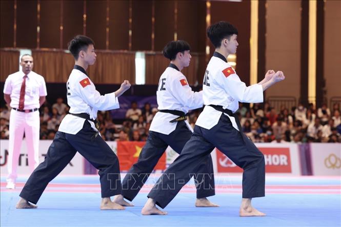 Ba VĐV Phạm Quốc Việt, Nguyễn Thiên Phụng, Nguyễn Trọng Phúc thi đấu ở chung kết nội dung Quyền tiêu chuẩn đồng đội nam và xuất sắc giành HCV với thành tích 7,54 điểm. Ảnh: Minh Quyết - TTXVN