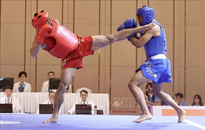 Dinh Van Bi (in red) wins a gold in the men's 70kg category after knocking out his Cambodian rival. VNA Photo