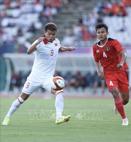 Pha đi bóng của Nguyễn Văn Tùng (9) trước sự kèm cặp của Komang Trisnanda (4, Indonesia). Ảnh: Minh Quyết - TTXVN