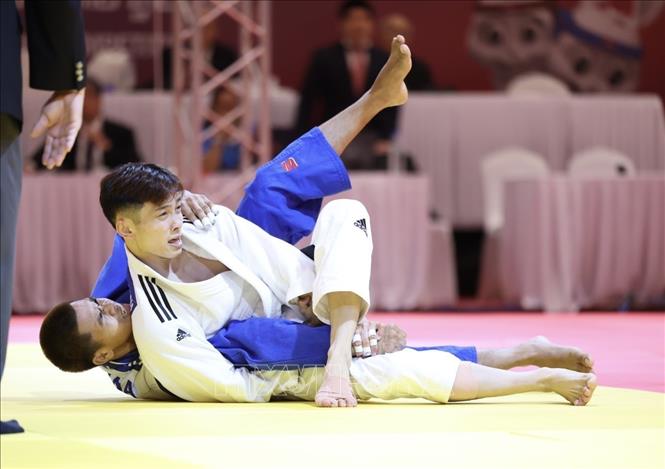 VĐV Nguyễn Hoàng Thành (áo trắng) thắng knock-out VĐV Thái Lan (áo xanh) bằng điểm ippon trong trận chung kết nội dung đối kháng hạng cân 55kg, giành HCV đầu tiên cho đội tuyển Judo. Đây là HCV đầu tiên ở nội dung đối kháng và là HCV thứ 3 của đội tuyển Judo VIệt Nam. Ảnh: Minh Quyết - TTXVN