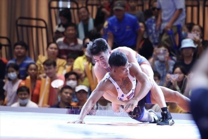 VĐV Bùi Tiến Hải (trên) đánh bại VĐV chủ nhà Campuchia để giành HCV ở hạng cân 60kg - HCV đầu tiên của đội tuyển Vật tại SEA Games 32. Ảnh: Minh Quyết - TTXVN