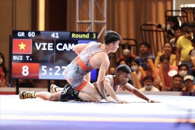VĐV Bùi Tiến Hải (trên) đánh bại VĐV chủ nhà Campuchia để giành HCV ở hạng cân 60kg - HCV đầu tiên của đội tuyển Vật tại SEA Games 32. Ảnh: Minh Quyết - TTXVN