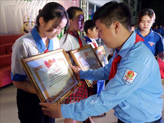 Anh Phạm Văn Hậu - Chủ tịch Hội đồng Đội tỉnh trao bằng khen cho các cá nhân có thành tích xuất sắc trong công tác Đội và phong trào thiếu nhi. Ảnh: Đức Hạnh - TTXVN 