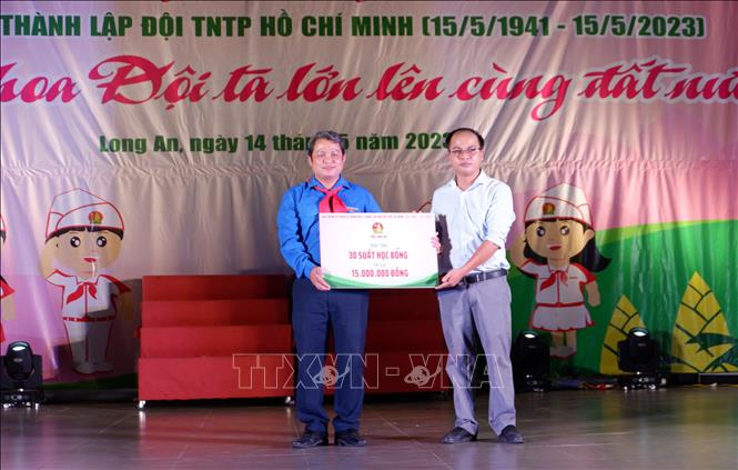 Ông Nguyễn Duy Điệp, xã Bình Lãng, huyện Tân Trụ trao hỗ trợ 30 suất học bổng cho đội viên tiêu biểu. Ảnh: Đức Hạnh - TTXVN 
