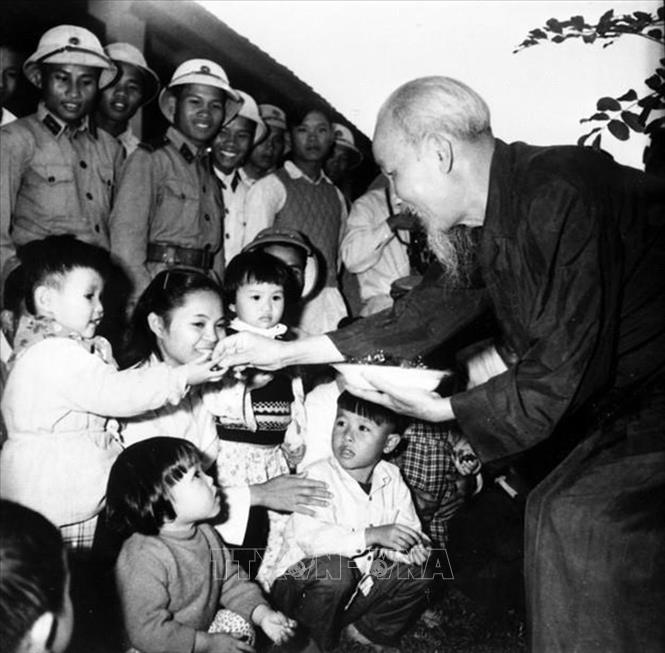 Chủ tịch Hồ Chí Minh thăm nhà trẻ, chia kẹo cho thiếu nhi là con cháu của công nhân Xí nghiệp gốm Dụ Phong và HTX Nông nghiệp Soáy Ngườn, thị xã Móng Cái (nay là TP Móng Cái, tỉnh Quảng Ninh). Ảnh: TTXVN