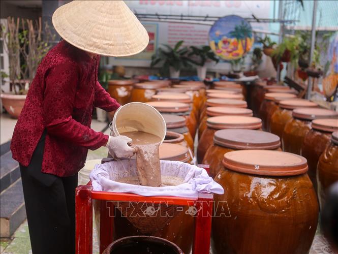 Villagers use bamboo filters to get fish sauce. VNA Photo: Trần Lê Lâm
