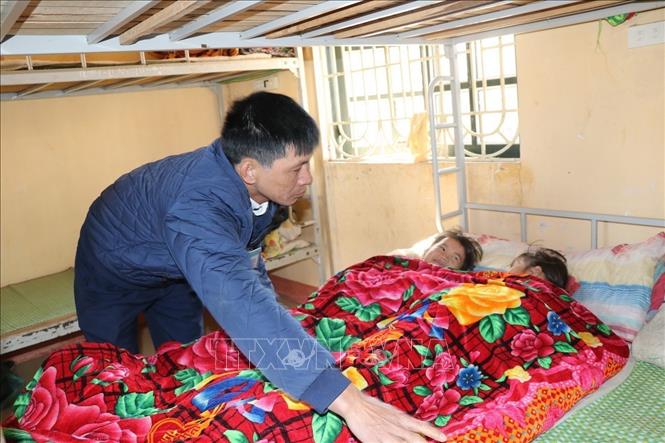 Thầy giáo Trường tiểu học và trung học cơ sở Kiên Thành, huyện Trấn Yên (Yên Bái) đắp chăn ấm cho học sinh khi ngủ để đảm bảo sức khỏe cho các em trước thời tiết rét hại vào đêm và sáng sớm. Ảnh: Đức Tưởng - TTXVN