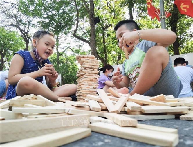Trẻ em háo hức với các trò chơi xếp gỗ tại tuyến phố đi bộ quanh Hồ Gươm. Ảnh: Thanh Tùng - TTXVN