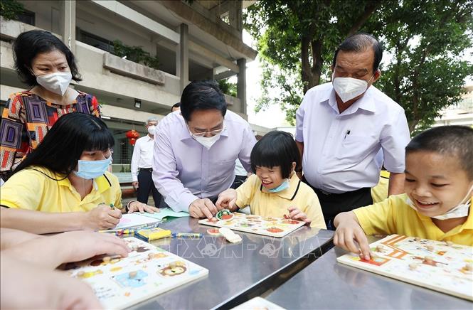 Thủ tướng Phạm Minh Chính thăm trẻ em đang được chăm sóc tại Trung tâm bảo trợ trẻ tàn tật mồ côi Thị Nghè nhân dịp Xuân Nhâm Dần. Ảnh: Dương Giang-TTXVN