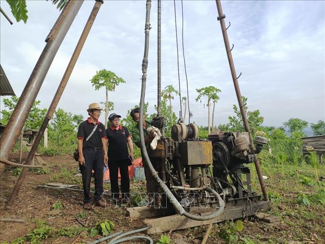 Vợ chồng ông Phan Ngọc Phượng và bà Nguyễn Thị Lý hỗ trợ người dân địa phương khoan giếng. Ảnh: TTXVN phát