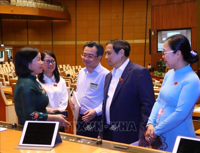 Thủ tướng Phạm Minh Chính với các đại biểu trao đổi bên lề phiên họp. Ảnh: Văn Điệp - TTXVN
