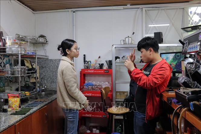 Nhân viên trong quán nói chuyện, trao đổi công việc với nhau bằng ngôn ngữ riêng. Ảnh: Chu Quốc Hùng-TTXVN
