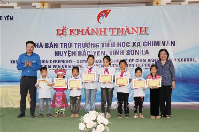 Bà Trương Mỹ Hoa, nguyên Phó Chủ tịch nước, Chủ tịch Quỹ học bổng Vừ A Dính trao học bổng cho các em học sinh có hoàn cảnh khó khăn tại xã Chim Vàn, huyện Bắc Yên. Ảnh: Hữu Quyết - TTXVN