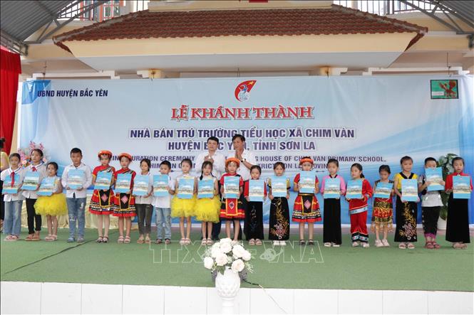 Lãnh đạo tỉnh Sơn La tặng học bổng cho các em học sinh xã Chim Vàn, huyện Bắc Yên. Ảnh: Hữu Quyết - TTXVN