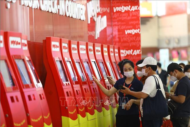 Passengers at Vietjet’s check-in booth at Noi Bai international airport in Hanoi. VNA Photo: Huy Hùng