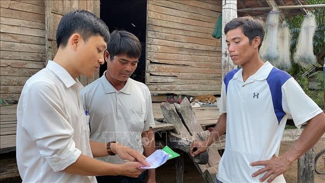 Trong ảnh: Chính quyền địa phương hướng dẫn thủ tục vay vốn ngân hàng để giúp bà con có vốn đầu tư sản xuất. Ảnh: Hồng Điệp - TTXVN
