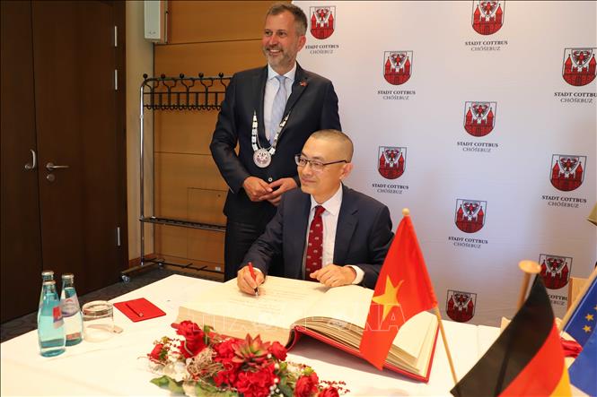 Trong ảnh: Đại sứ Vũ Quang Minh ký Sổ vàng của thành phố Cottbus. Ảnh: Mạnh Hùng - PV TTXVN tại Đức