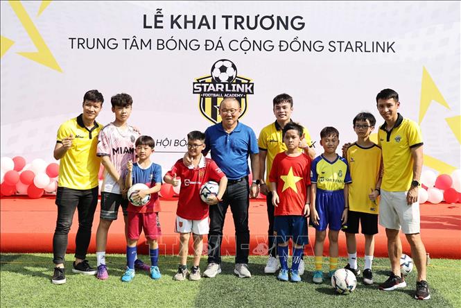 Cựu HLV trưởng đội tuyển bóng đá Việt Nam Park Hang Seo và cầu thủ Đỗ Hùng Dũng chụp ảnh lưu niệm với các bạn nhỏ. Ảnh: Trung Kiên - TTXVN