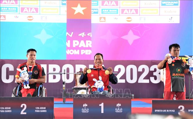 VĐV Lê Văn Công trên bục nhận 2 HCV hạng cân 49kg với thành tích 168kg và tổng cử là 496kg tại ASEAN Para Games 12. Đây là HCV ở kỳ ASEAN Para Games thứ 6 liên tiếp của VĐV kỳ cựu này. Ảnh: Huỳnh Thảo - P/v TTXVN tại Campuchia