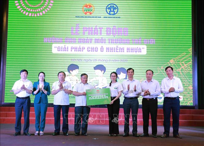 Phó Chủ tịch Hội Nông dân Việt Nam Đinh Khắc Đính trao tặng tượng trưng thùng và xe đựng rác cho Hội nông dân huyện Hoài Đức, thành phố Hà Nội. Ảnh: Vũ Sinh - TTXVN
