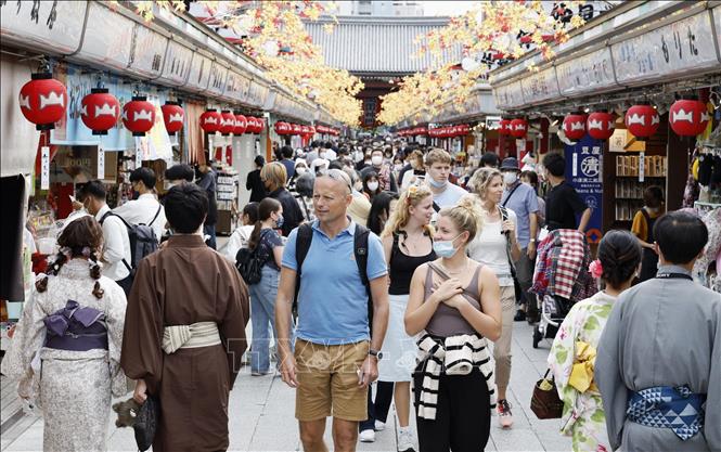 Khách du lịch mua sắm trên một tuyến phố thương mại ở Tokyo, Nhật Bản. Ảnh: Kyodo/TTXVN