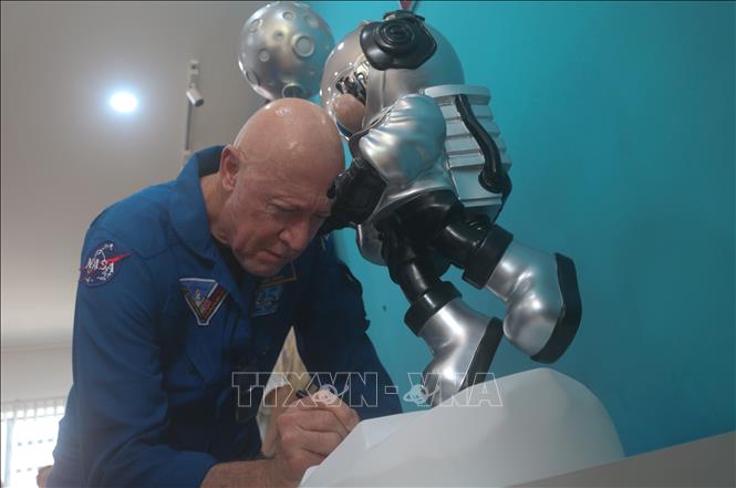 Trong ảnh: Ông Michael A. Baker, cựu Phi hành gia NASA, cựu Thuyền trưởng Hải quân Hoa Kỳ ký tặng mô hình tượng phi hành gia tặng cho Trường THPT Vị Thanh. Ảnh: Thúy Hằng - TTXVN