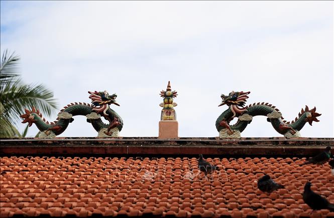 Trong ảnh: Biểu tượng “Lưỡng long chầu nguyệt” đặc trưng kiến trúc Á Đông được làm nổi công phu trên mái Đình Thần Thắng Tam. Ảnh: Hồng Đạt - TTXVN
