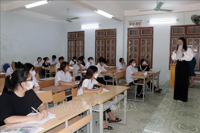 Giám thị tại một điểm thi ở thành phố Sơn La hướng dẫn thí sinh điền thông tin vào tờ giấy thi. Ảnh: Hữu Quyết – TTXVN