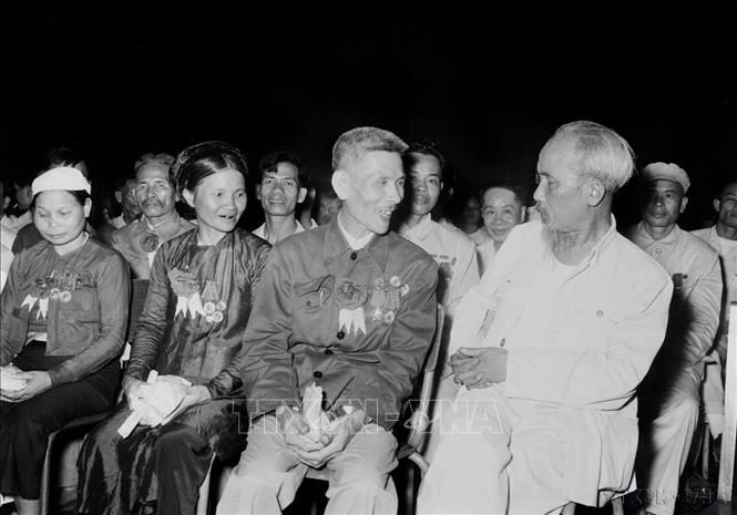 Chủ tịch Hồ Chí Minh nói chuyện thân mật với Anh hùng Lao động Nguyễn Phúc Đồng (Ngành Quân giới) và nữ Anh hùng Nguyễn Thị Năm (Dệt Nam Định) trong buổi họp mặt các đại biểu dự Đại hội liên hoan Anh hùng, Chiến sĩ thi đua Công-Nông-Binh toàn quốc lần thứ II (Hà Nội, 7/7/1958). Ảnh: TTXVN
