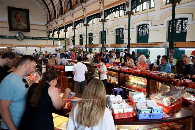 Trong ảnh: Khách quốc tế chọn mua bưu thiếp tại Bưu điện Trung tâm Thành phố Hồ Chí Minh. Ảnh: Hồng Đạt - TTXVN
