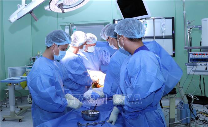 Trong ảnh: Đại tá, PGS.TS bác sĩ Lê Quang Trí (thứ 2 từ trái sang), Giám đốc Bệnh viện Quân y 7A hướng dẫn cho các bác sỹ xử lý trong một ca mổ xương đùi cho bệnh nhân. Ảnh: Xuân Khu-TTXVN