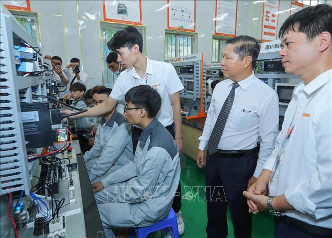 Thứ trưởng Bộ LĐ, TB&XH Lê Tấn Dũng và các đại biểu tham quan Trung tâm đào tạo sản xuất thông minh HNIVC-FUNA. Ảnh: Hoàng Hiếu - TTXVN